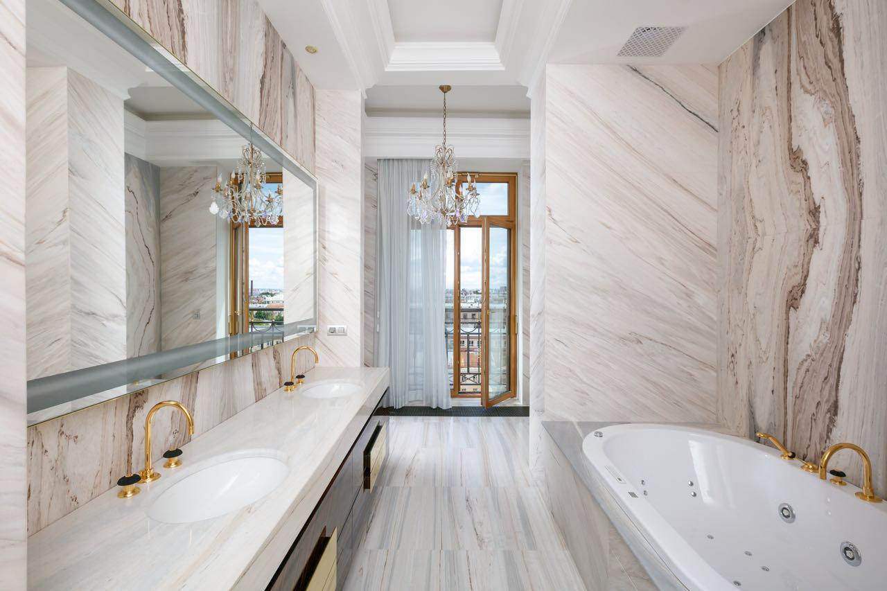 Luxurious bathroom with marble walls and a large bathtub.
