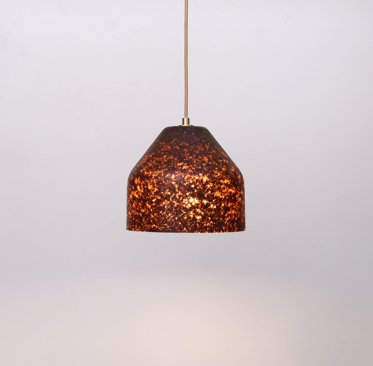 Pendant light with a brown, textured shade and bronze elements  on a white background