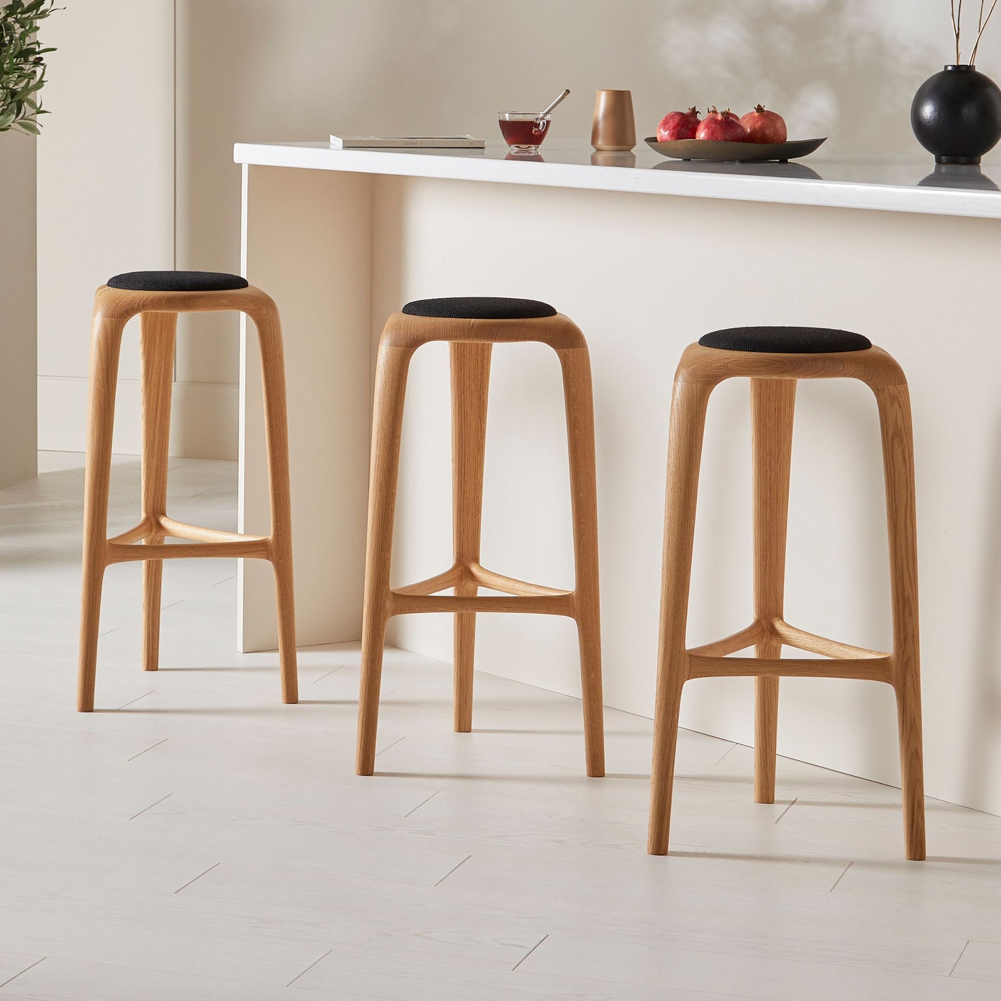 Flow upholstered stool in oak with an integrated wooden footrest