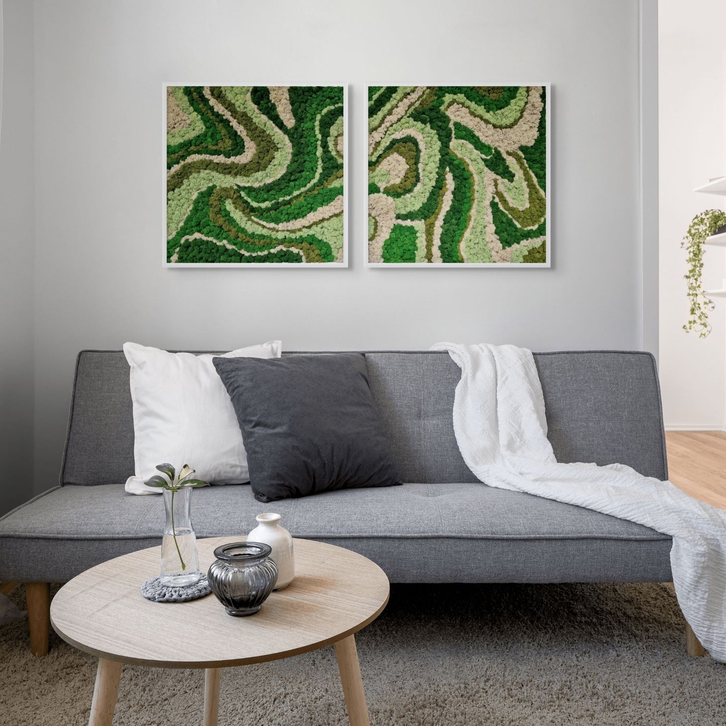 Gray sofa in a living room with two green abstract paintings on the wall.