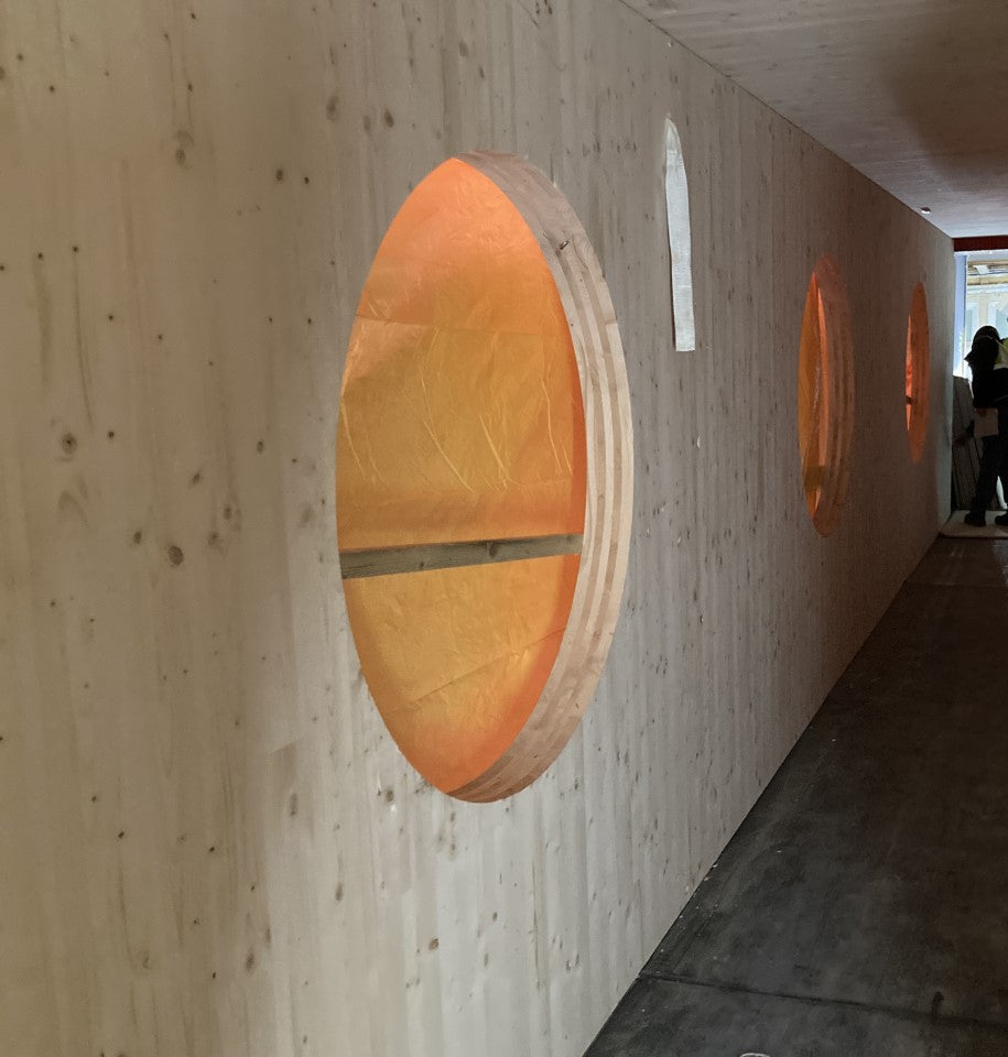 Long hallway made in raw wood CLT with circular windows 